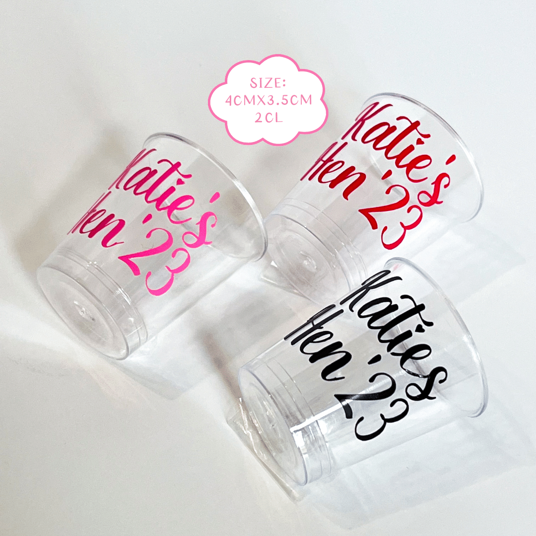 Personalised plastic hen party shot glasses.