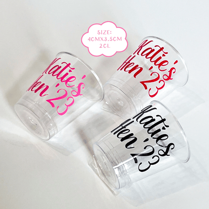 Personalised plastic hen party shot glasses.