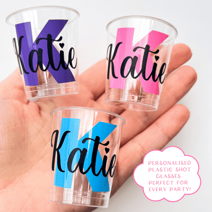 Personalised plastic name shot glasses.