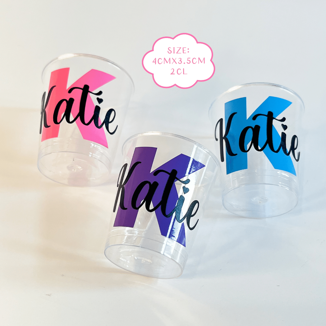 Personalised plastic name shot glasses.