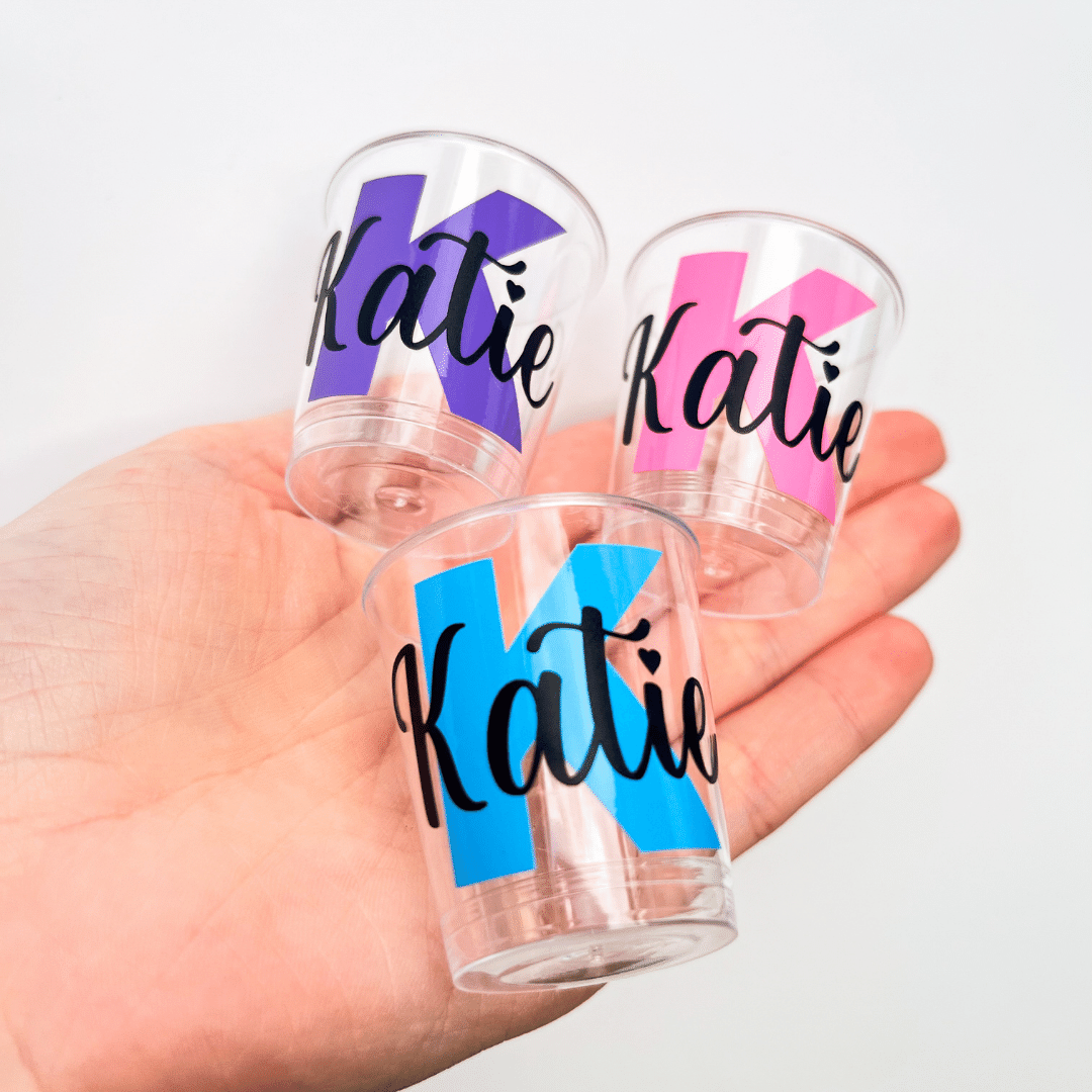 Personalised plastic name shot glasses.