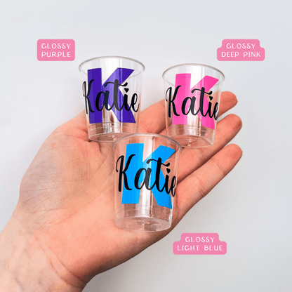 Personalised plastic name shot glasses.